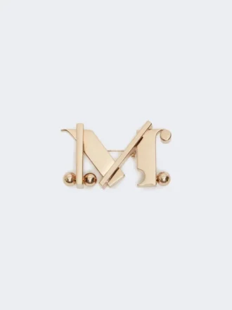 Monogram-broche i metal, guld