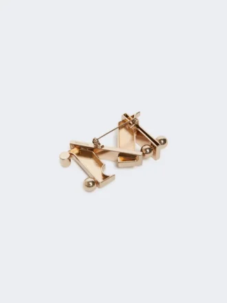 Monogram-broche i metal, guld